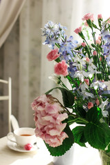 Obraz na płótnie Canvas Bouquet of seasonal flowers carnation hydrangea delphinium on the dining table