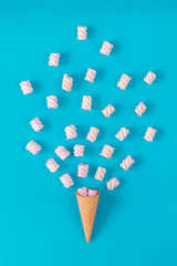 Waffle cone with marshmallow bouquet on blue background