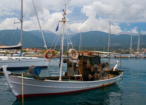 Small white fishing boat in the harbour of Fiskardo on the ionian island Kefalonia in Greece