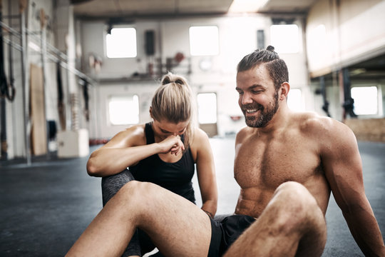 Fit people laughing while taking a break from working out