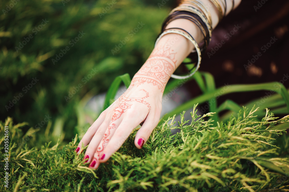 Wall mural woman hands with black mehndi tattoo. hands of indian bride girl with black henna tattoos. fashion.  - Wall murals