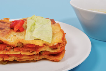Lasagna with vegetables on a blue
