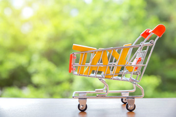 Tax Concept.Word tax in shopping carts on light bokeh green background