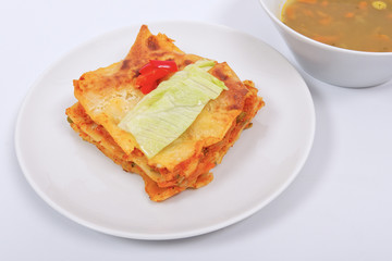 Lasagna with vegetables on a white