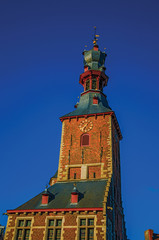 Detail of tower at sunset and blue sky in the City Center of Tielt. Charming and quiet village in the countryside, near Ghent and surrounded by agricultural fields. Western Belgium. Retouched photo.