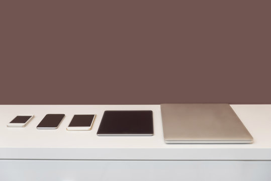 Row of mobile devices on dresser