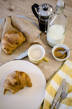 Italian cornetto on plate, French press and cappuccino