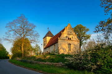 Fototapeta premium Ostseite der denkmalgeschützten historischen Dorfkirche Rambow im frühen Morgenlicht