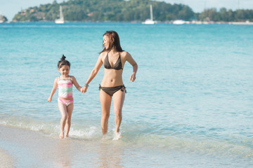 Mother And Daughter Walking and run On Beautiful Beach