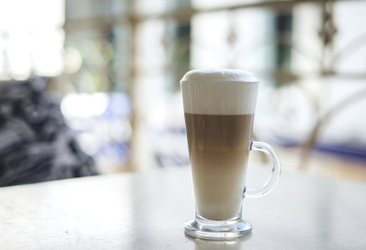 Glass of hot latte on a wooden table