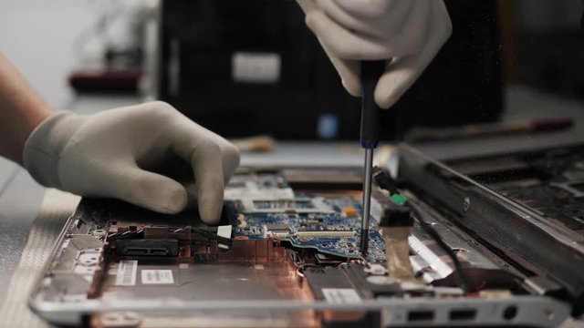Closeup shot of male hands working on disassembling and cleaning circuit board in laptop using brush repair pc processor and change cooler - Powered by Adobe
