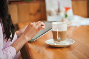 Close up hand woman using tablet in coffee shop