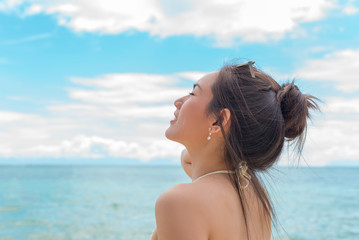 Fototapeta na wymiar Beautiful young woman in sexy bikini standing at sea beach