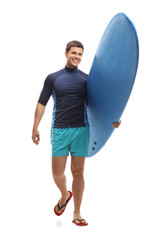 Surfer holding a surfboard and walking towards the camera