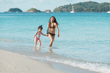 Mother And Daughter Walking and run On Beautiful Beach