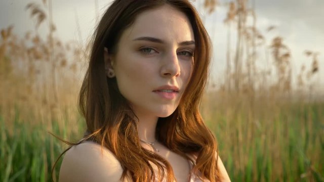 Portrait of young ginger girl in a forest, looking at camera, thinking, dreaming, nature background, concept 50 fps