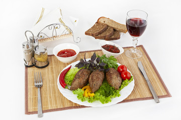 Cutlets with greens, tomatoes and cucumbers. Serve with black or white bread and a glass of red wine.
