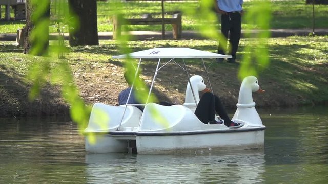 Couple using pedal boat on the lake and relaxing, slow motion shot at 240fps
