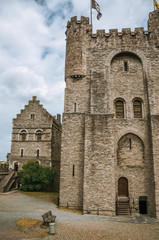 Fototapeta na wymiar Stone watch-tower, walls and flags inside the Gravensteen Castle at Ghent. In addition to intense cultural life, the city is full of Gothic buildings and Flemish style architecture. Northern Belgium.