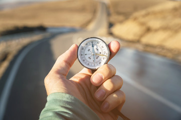 Compass in Hand mountain road background .Vintage Tone