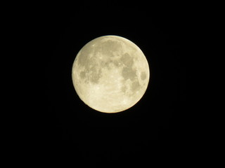 Isolated full moon with lunar craters, seas and mountains visible