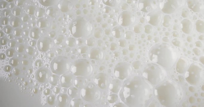 A very close video of milk bubbles popping.