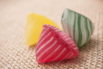 closeup of colorful traditional candies on hessian background