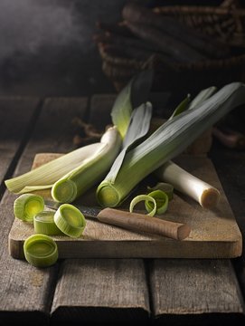 Fresh leeks on wooden chopping board