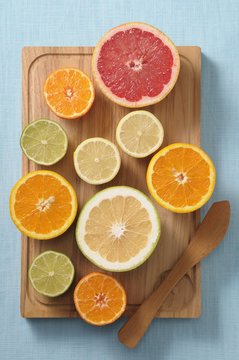 Halved citrus fruits on a wooden board