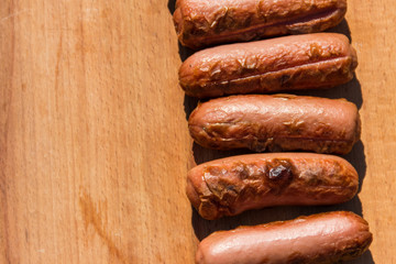 Grilled sausages on wooden board