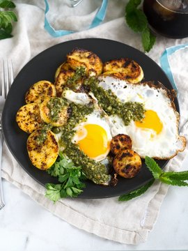 Fried eggs with plantain and chimichurri sauce for breakfast