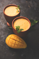 Mango Lassi, Indian popular summer drink in a terracotta glass, selective focus