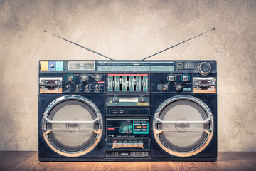 Retro design ghetto blaster stereo radio cassette tape recorders boombox from circa 80s front concrete wall background. Vintage instagram old style filtered photo