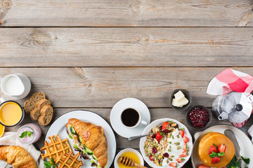 Breakfast table with waffles, granola, yogurt, pancakes, juice, coffee