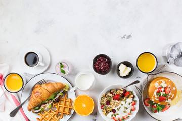 Breakfast table with waffles, granola, yogurt, pancakes, juice, coffee