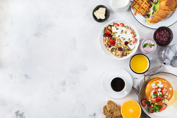 Breakfast table with waffles, granola, yogurt, pancakes, juice, coffee