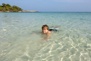 Fototapeta na wymiar boy enjoys the clear blue ocean