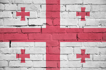 Georgia flag is painted onto an old brick wall
