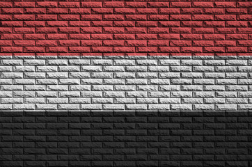 Yemen flag is painted onto an old brick wall