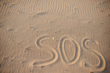 Fototapeta na wymiar The inscription on the sand beach SOS