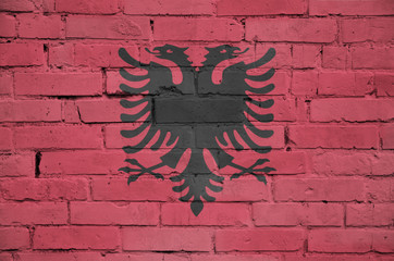 Albania flag is painted onto an old brick wall
