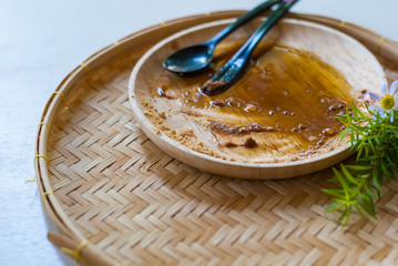 Empty wooden plate after dessert has been eaten, only sugar and sweet sauce left