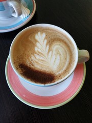 Delicious fresh cappuccino coffee on wooden table