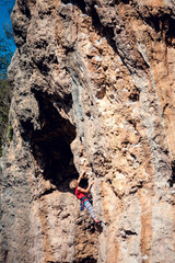 A woman climbs the rock.