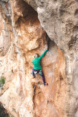 A woman climbs the rock.