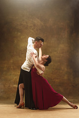 Dance ballroom couple in red dress dancing on studio background. - obrazy, fototapety, plakaty