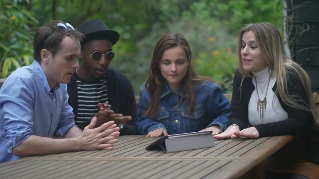 Young Casual Garden Watching Tablet Miss Goal. Handheld shot of group of millennial friends watching something suspenseful on the tablet