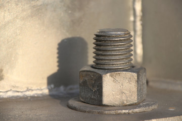 Big Screw and nut on metal background. Nut and bolt hold something tight.