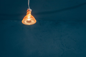 Halogen bulb with warm light in a dark room, dim light, copy space