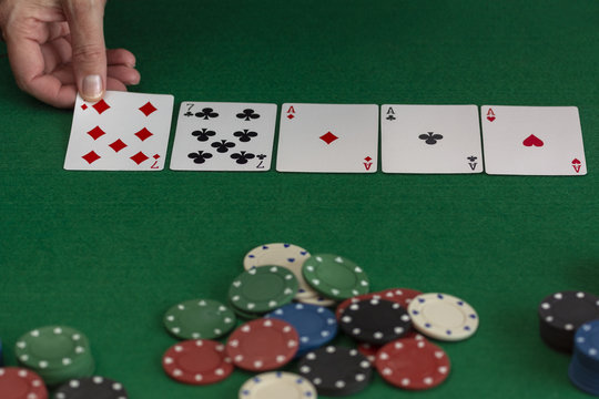 mujer jugando al póquer en una mesa de casino verde y colocando las cartas 